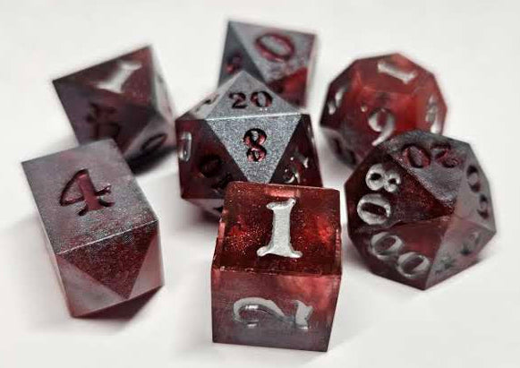 Set of red and silver polyhedral dice on a white background